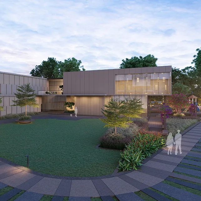 The clubhouse with a glass upper floor across a landscaped lawn at Orchid Platinum