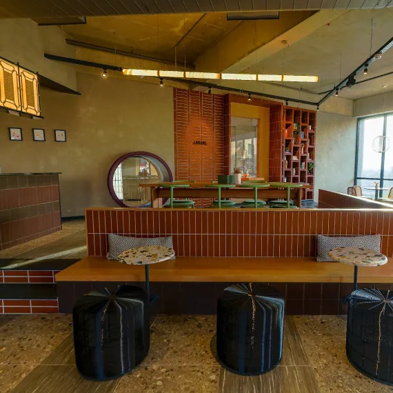 Tiled seating, a reading nook and a café counter in the clubhouse at Orchid Piccadilly