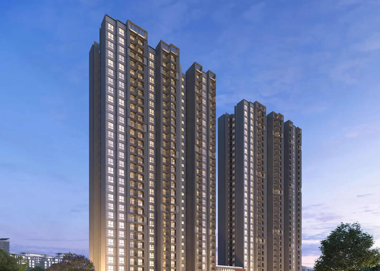 Two groups of tall apartment towers lit at dusk above the trees at Orchid South Park